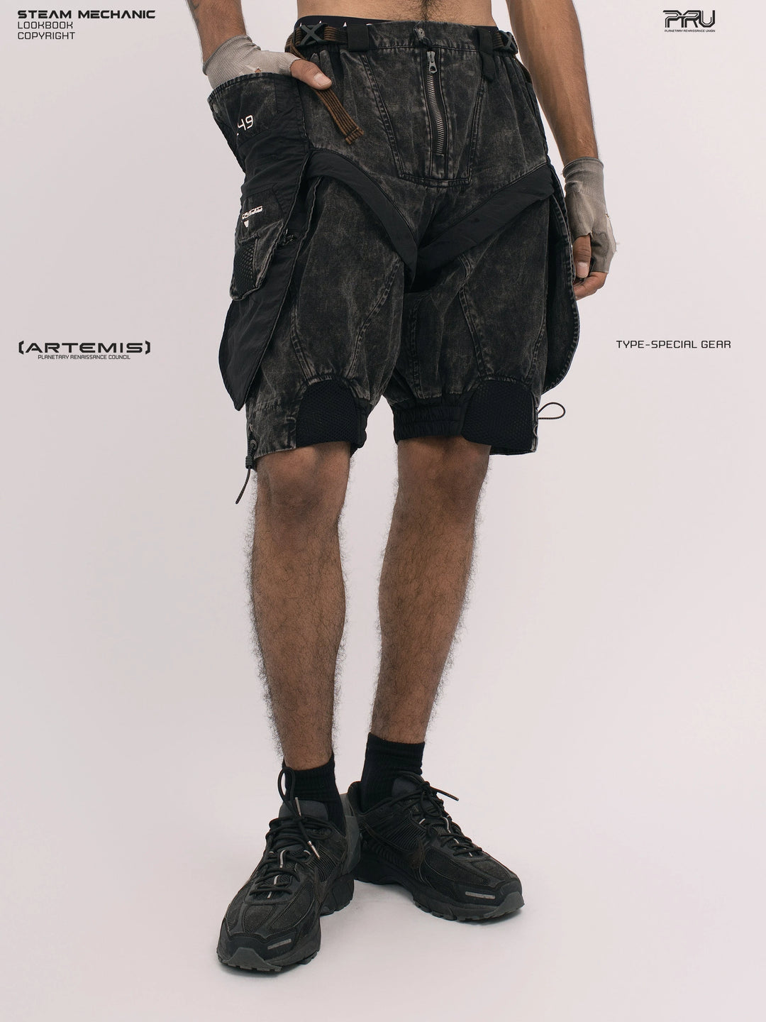 ARTEMIS blackbird black detachable technical shorts — angled front modeled view with hand in pocket