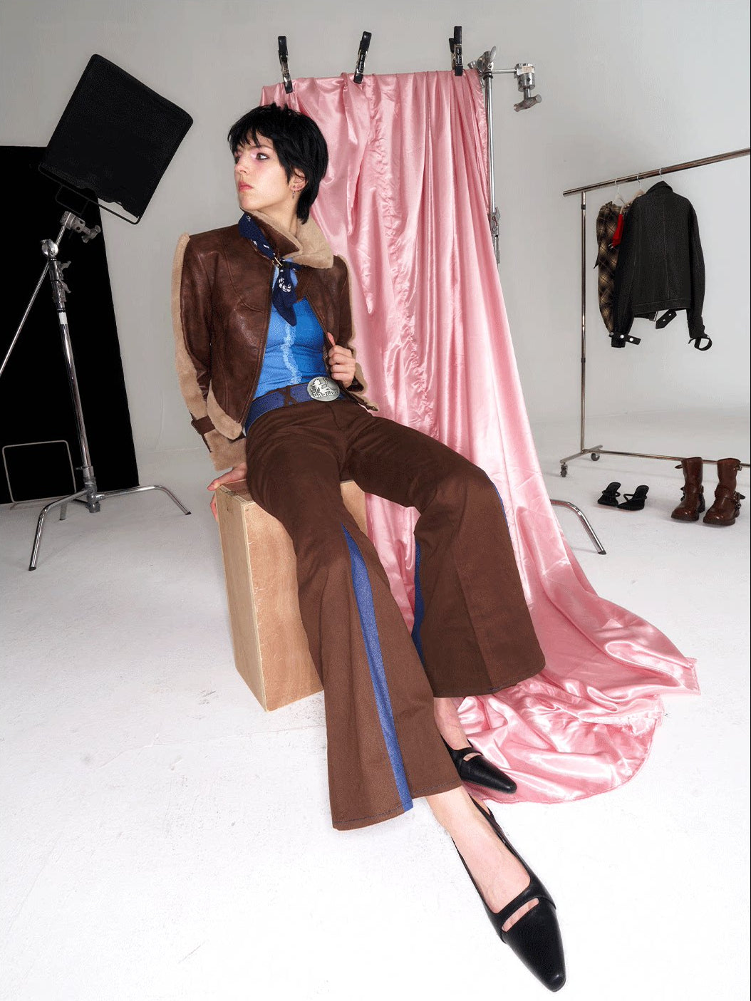 NEXT PASSPORT denim-panel low-rise flared pants in brown — seated styling with a brown jacket.