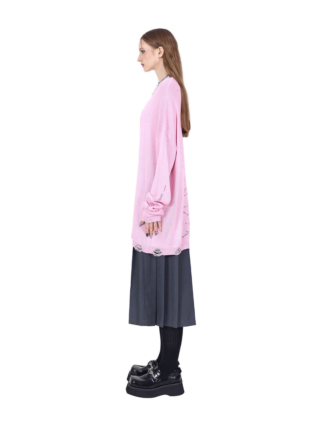 PINKSPINK ELECTRIC MOON distressed open-knit sweater in pink — full-length side view showing the loose hem over a pleated skirt