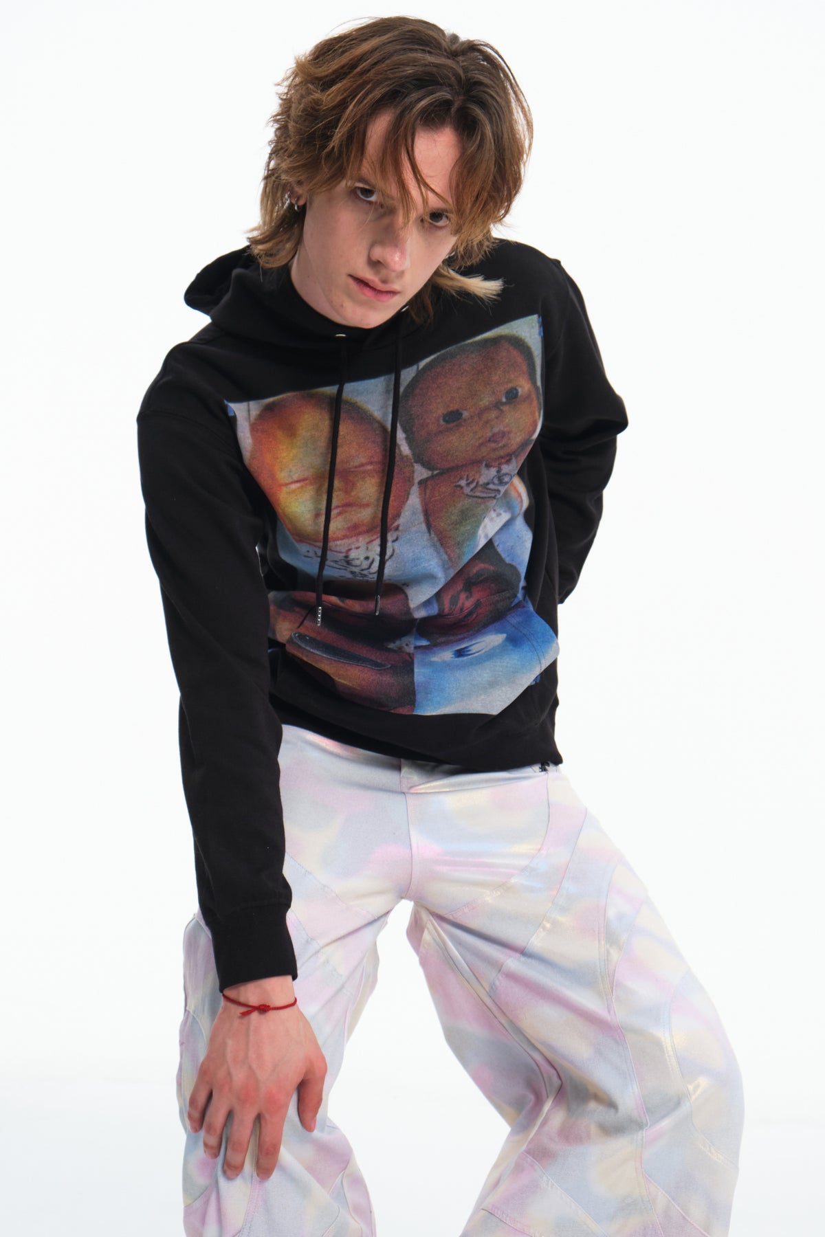 EMBRYO ABCD FOUR CHILDREN black graphic hoodie — leaning modeled view showing the front graphic and sleeve cuffs