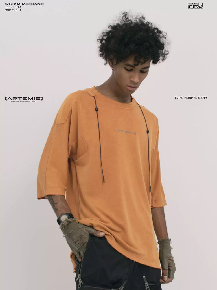 LIGHTSHADOW eclipse orange deconstructed technical tee — front three-quarter view with one hand at the hem
