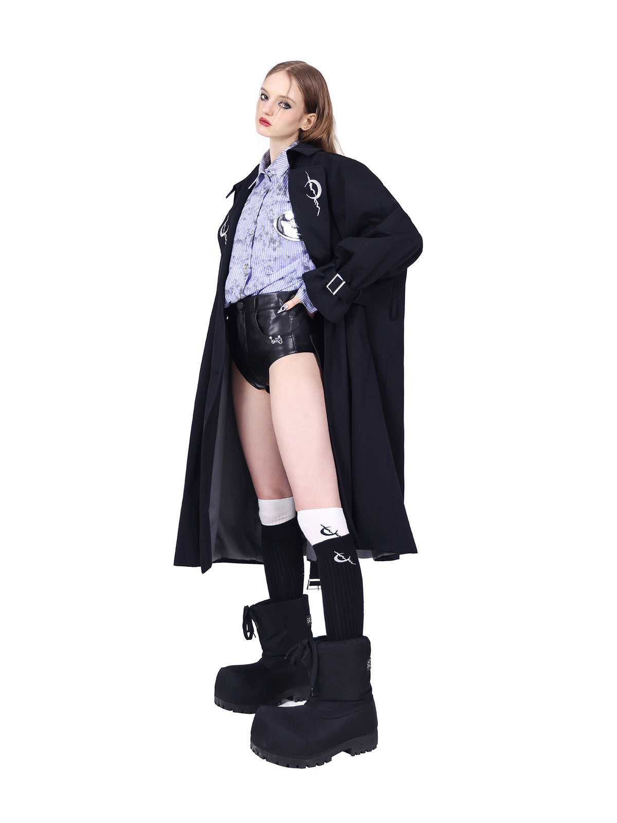 PINKSPINK ELECTRIC MOON reversible patchwork trench coat in black — angled open-front modeled view showing cuff buckles and crescent lapels