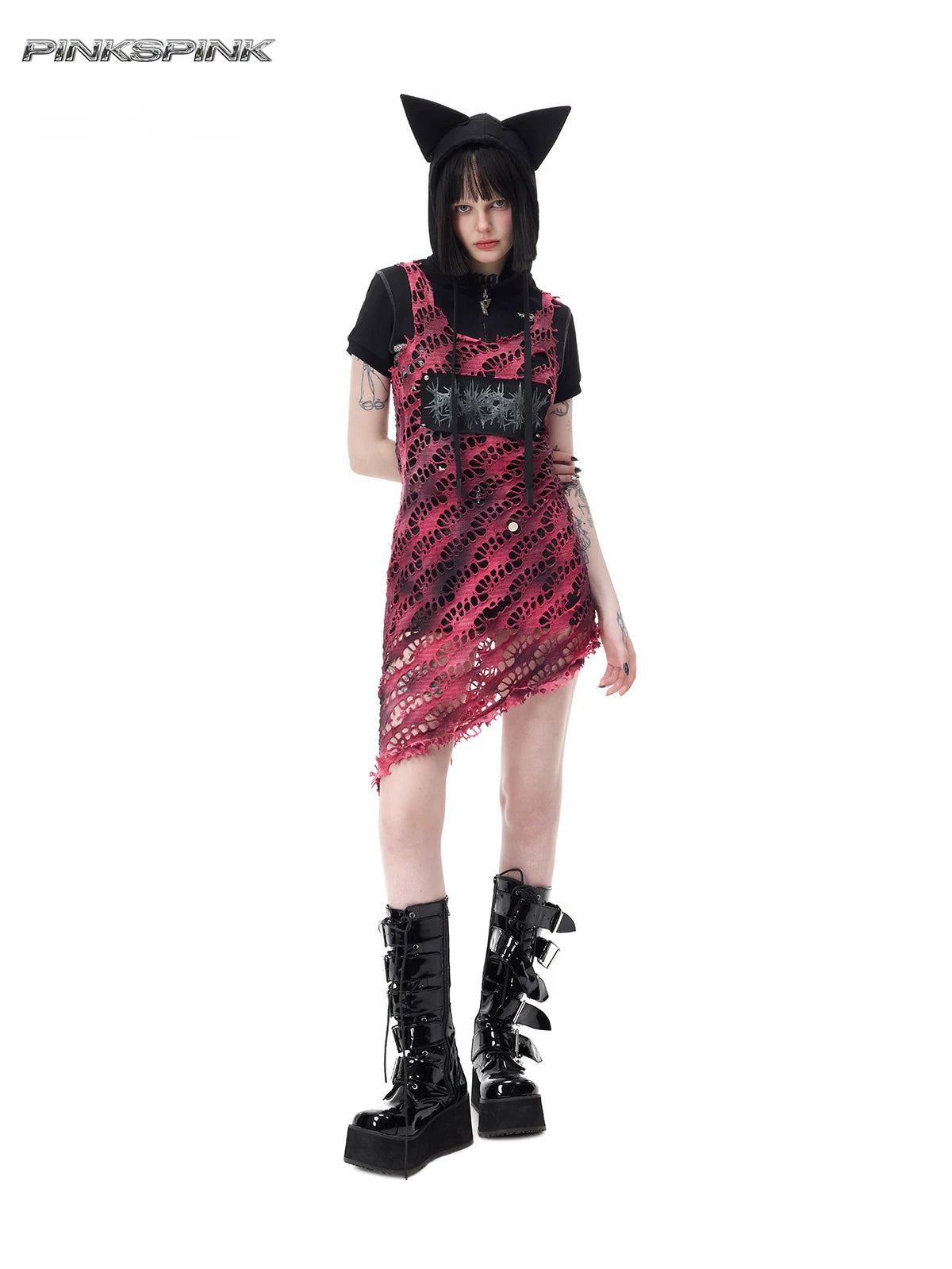 PINKSPINK AFTERGLOW distressed open-knit asymmetric dress in hot pink — full-length modeled view layered over a separate black top and shorts with a cat-ear hood accessory
