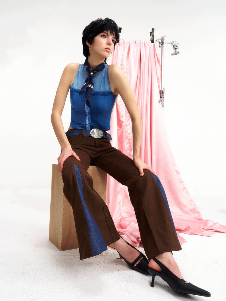 NEXT PASSPORT denim-panel low-rise flared pants in brown — seated front editorial view.