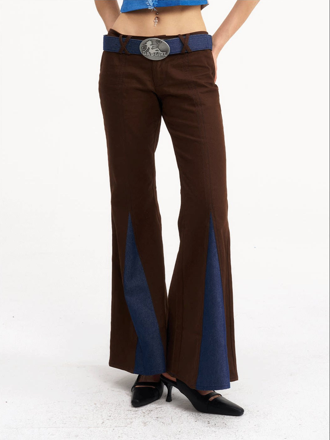 NEXT PASSPORT denim-panel low-rise flared pants in brown — front waist-down close-up showing the belt and flared legs.
