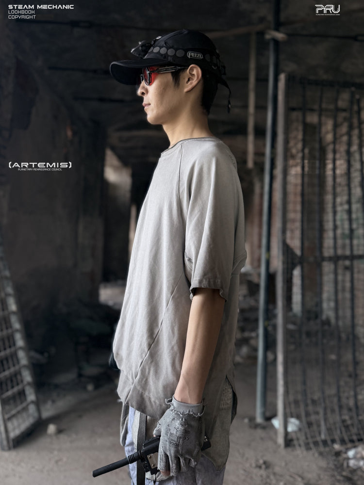 ERODED SPINE distressed asymmetric tee in oxidized white — side profile showing the angled hem and sleeve