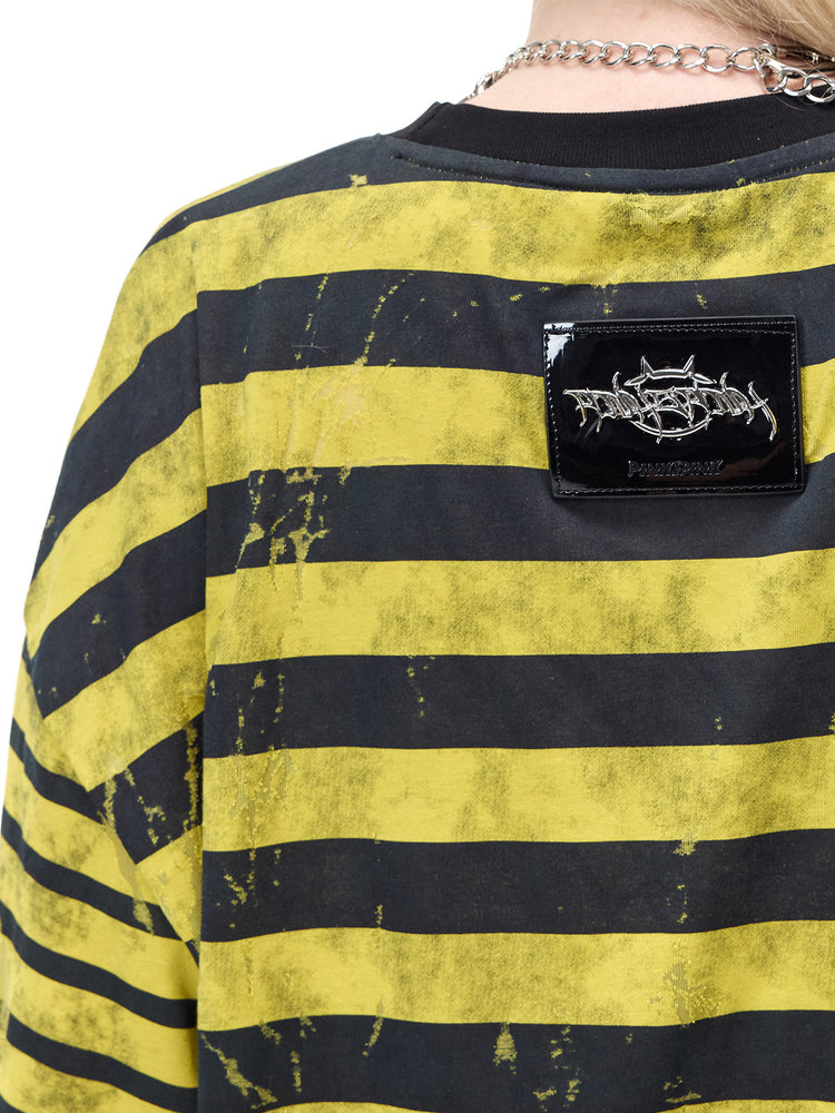 PINKSPINK STATIC asymmetric striped burnout long-sleeve tee in black and yellow — close-up of the metallic back badge and worn stripe texture