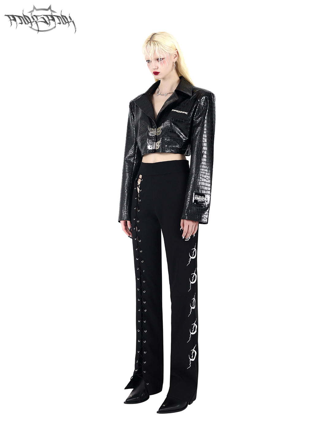 PINKSPINK FLAME BUCKLE — Black cropped jacket, three-quarter view styled with trousers.