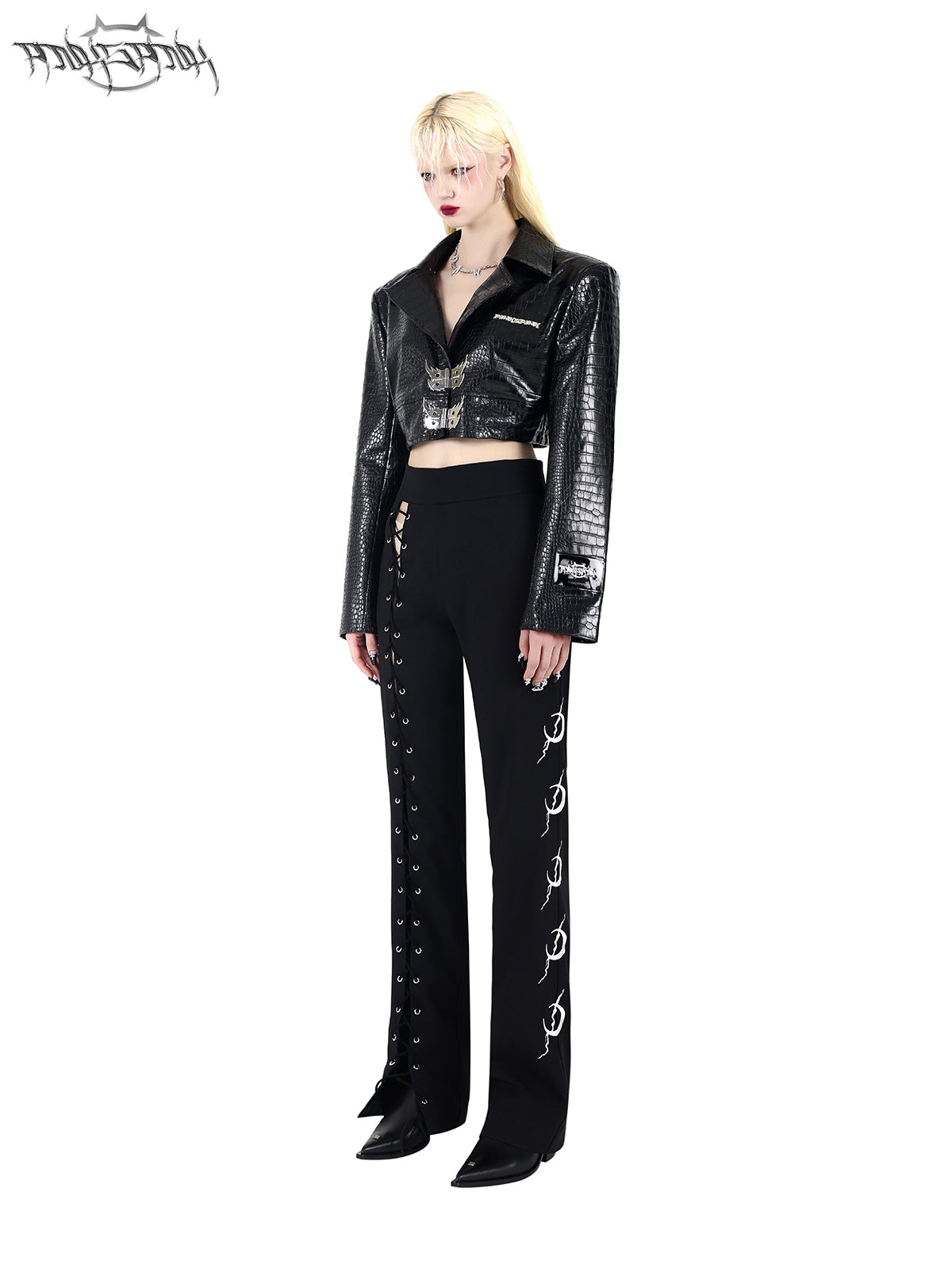 PINKSPINK FLAME BUCKLE — Black cropped jacket, three-quarter view styled with trousers.