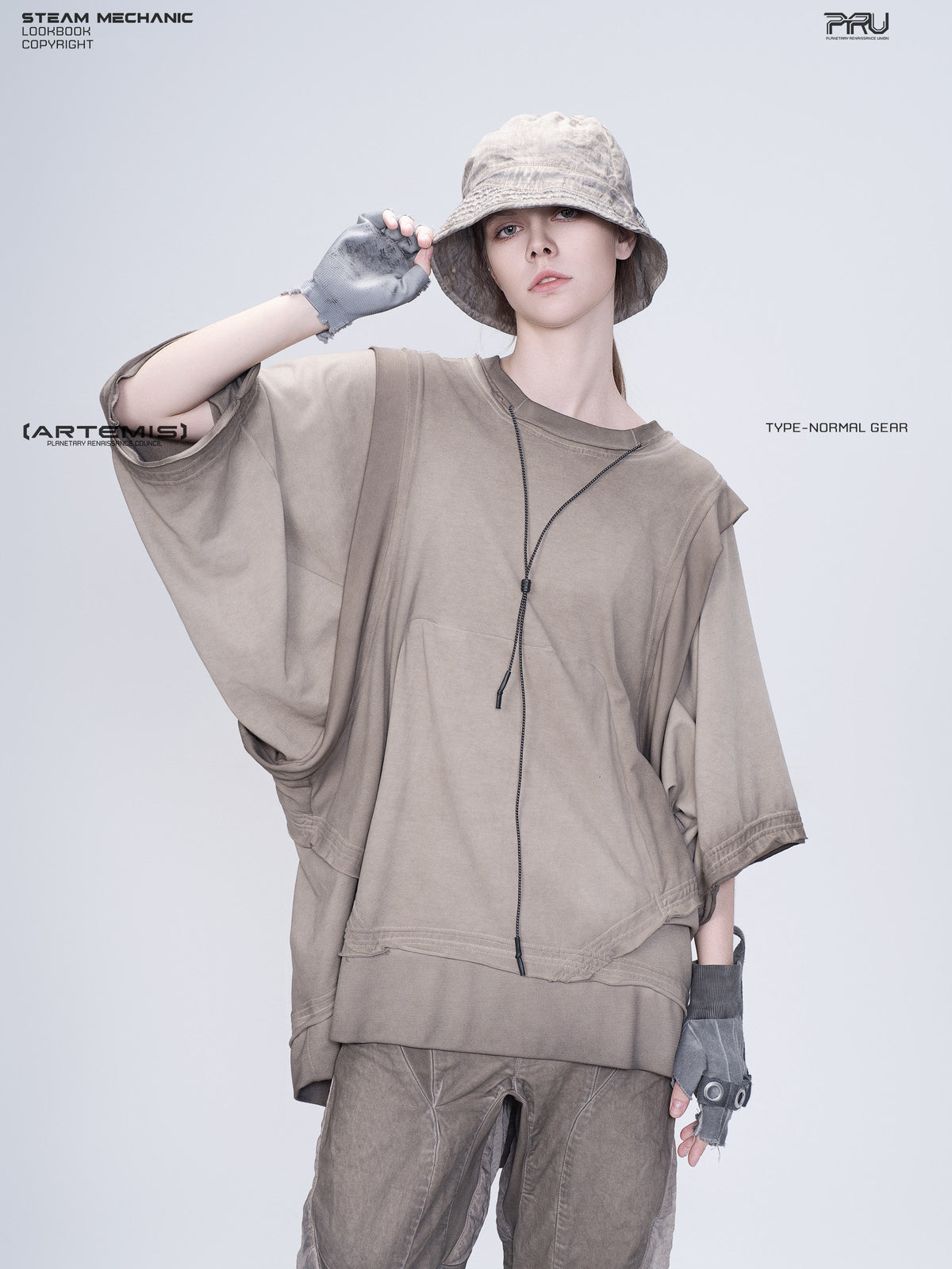 PIONEER mercury brown distressed nylon bucket hat — three-quarter modeled view with one hand holding the brim