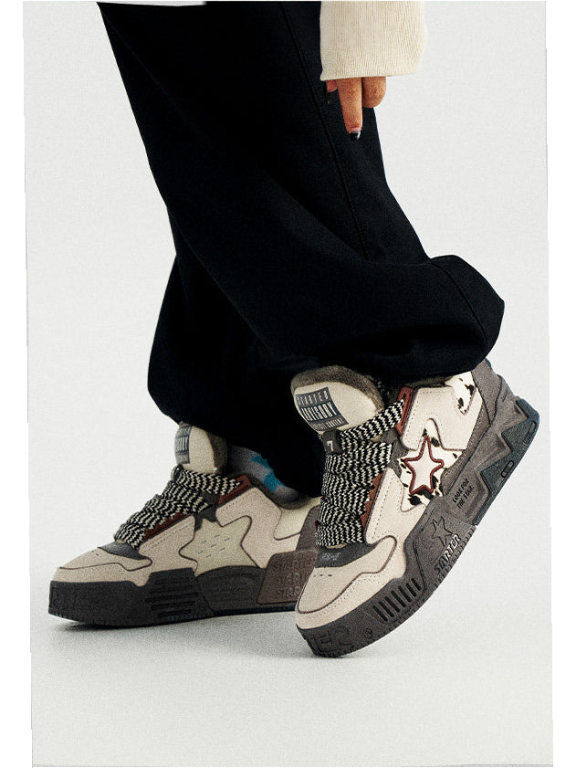 STARTER ZOO Zebra Gray fleece-lined platform sneakers worn with black trousers, showing broad patterned laces and animal-pattern star panels