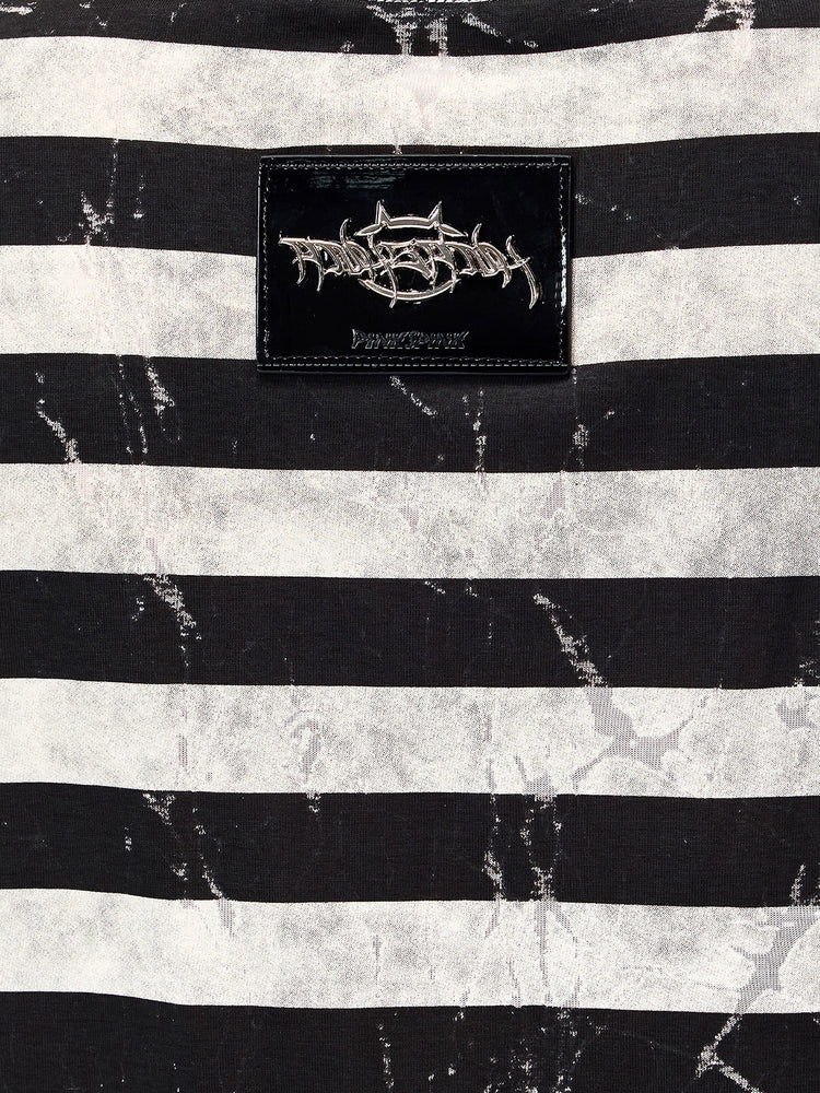 PINKSPINK STATIC asymmetric striped burnout long-sleeve tee in black and white — macro close-up of the raised metallic back badge and distressed striped fabric