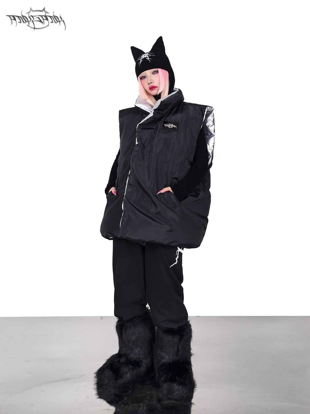 PINKSPINK ORBIT reversible padded vest in black silver — black-side full-length modeled view with hands in the pockets