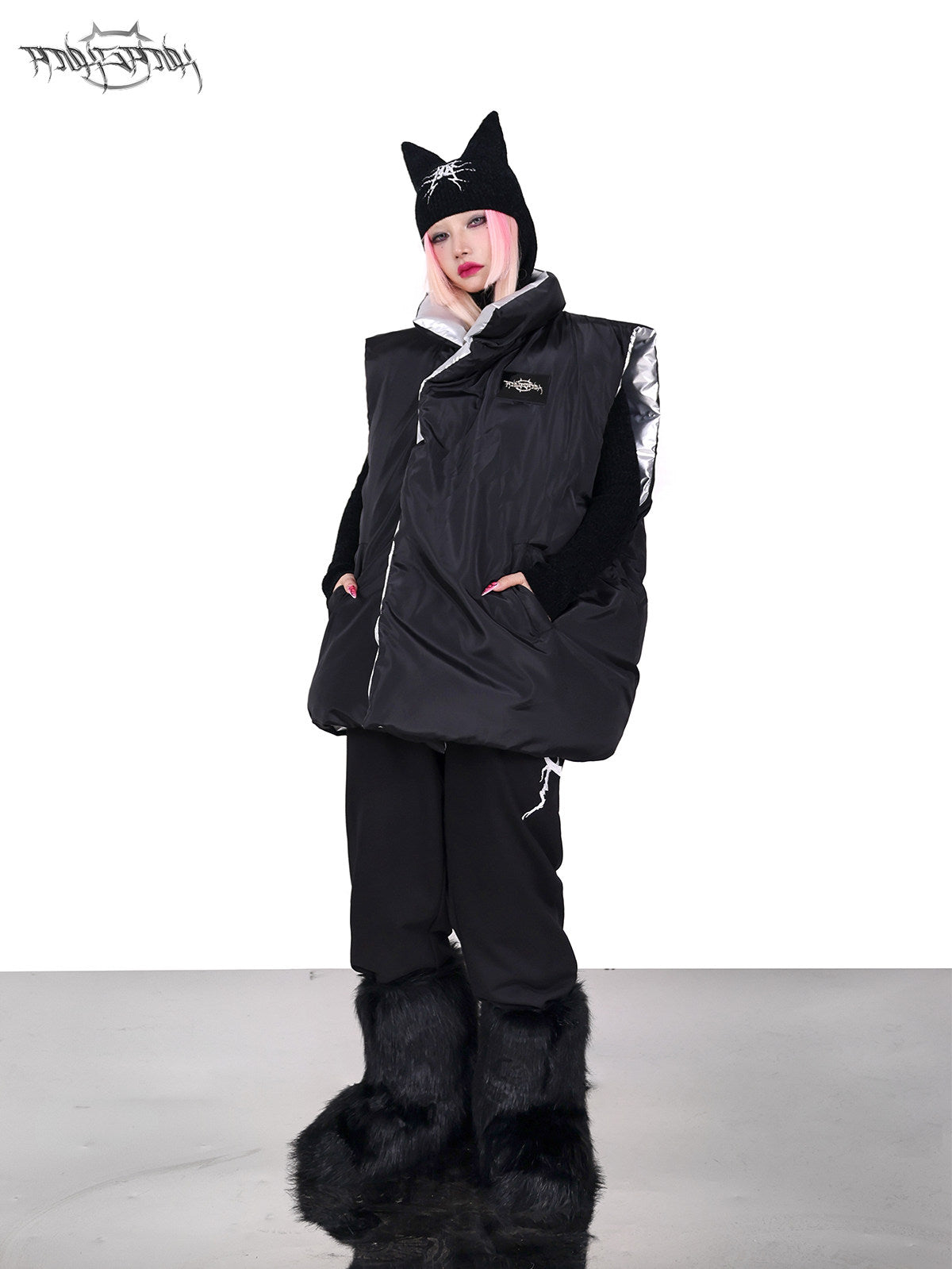 PINKSPINK ORBIT reversible padded vest in black silver — black-side full-length modeled view with hands in the pockets