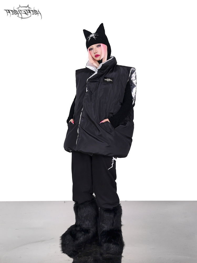 PINKSPINK ORBIT reversible padded vest in black silver — black-side full-length modeled view with hands in the pockets