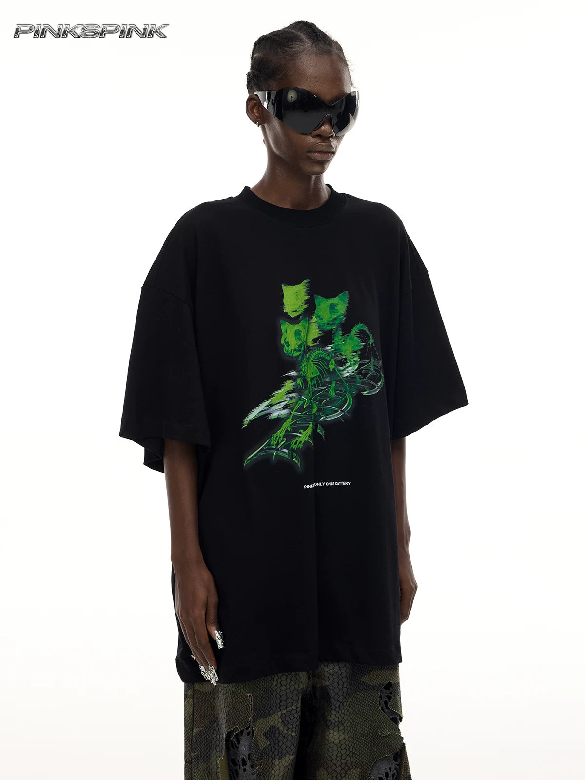 PINKSPINK MONSTER cat-skeleton oversized graphic tee in black — angled front modeled detail showing the green cat-skeleton graphic