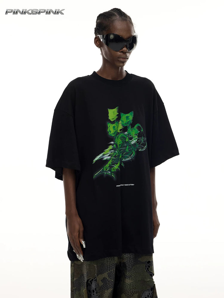 PINKSPINK MONSTER cat-skeleton oversized graphic tee in black — angled front modeled detail showing the green cat-skeleton graphic