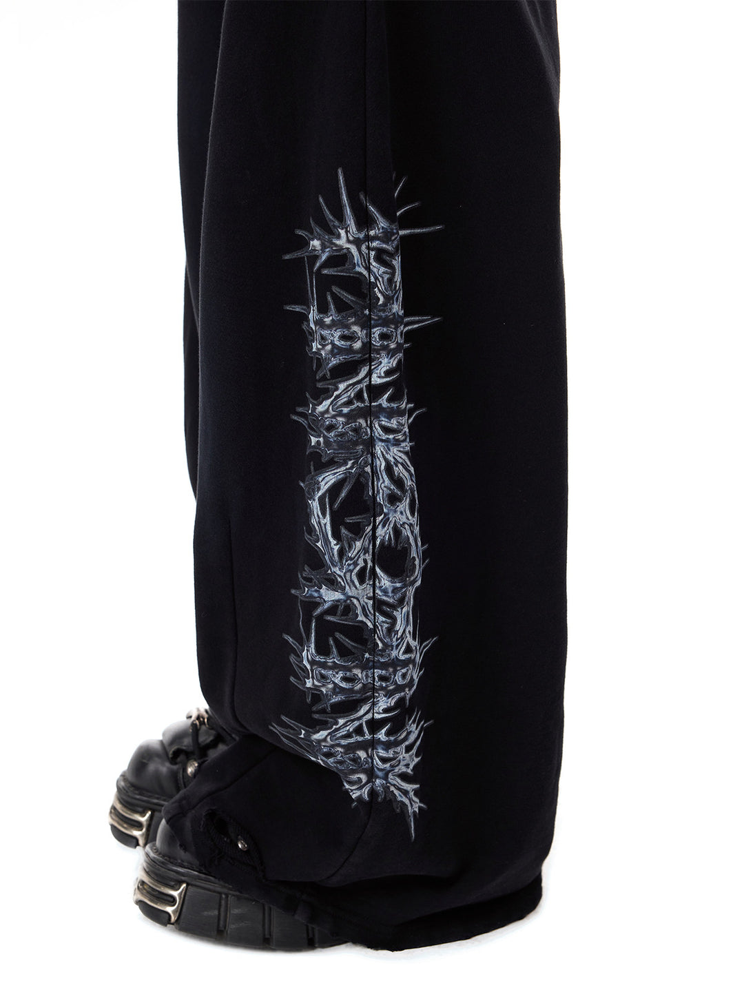 PINKSPINK CATPAW rhinestone curved-leg sweatpants in black — close lower-leg detail of the thorn print and distressed hem
