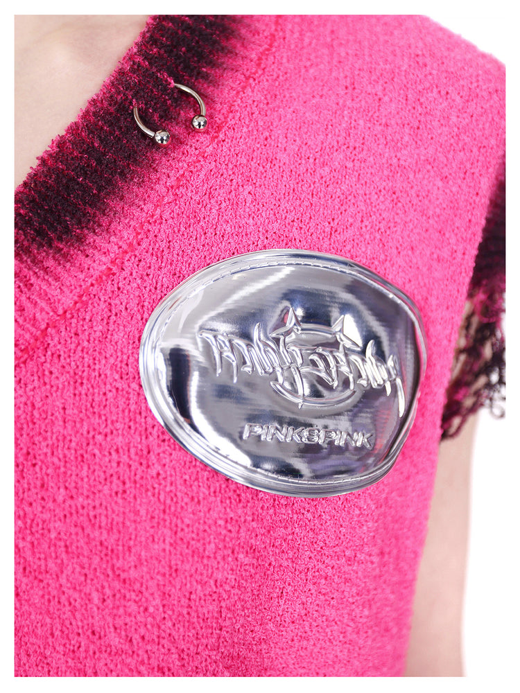 PINKSPINK REBEL distressed ring-detail knit vest in pink — macro close-up of the metal neckline ring and raised silver-tone brand badge