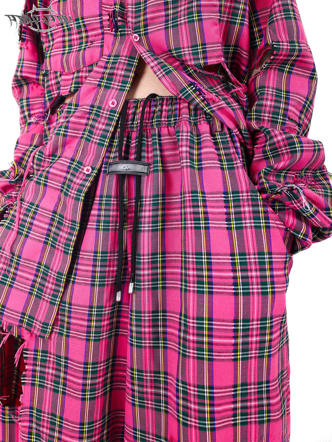 PINKSPINK PINK RIOT distressed plaid wide-leg pants — pink plaid drawstring waist and brand patch close-up