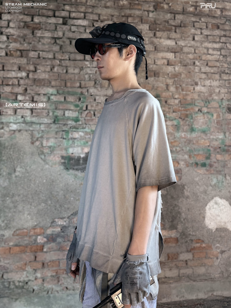ERODED SPINE distressed asymmetric tee in oxidized white — side modeled view showing the loose sleeve and asymmetric hem