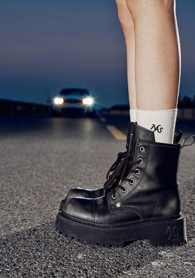 NAWS KNIGHT leather platform lace-up boots in SEA NIGHT BLACK — nighttime close-up styled view on pavement with a car in the background.