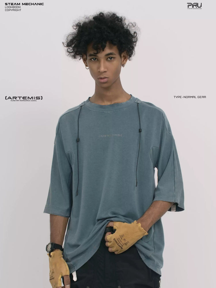 LIGHTSHADOW mycelium blue deconstructed technical tee — front three-quarter view holding the hem