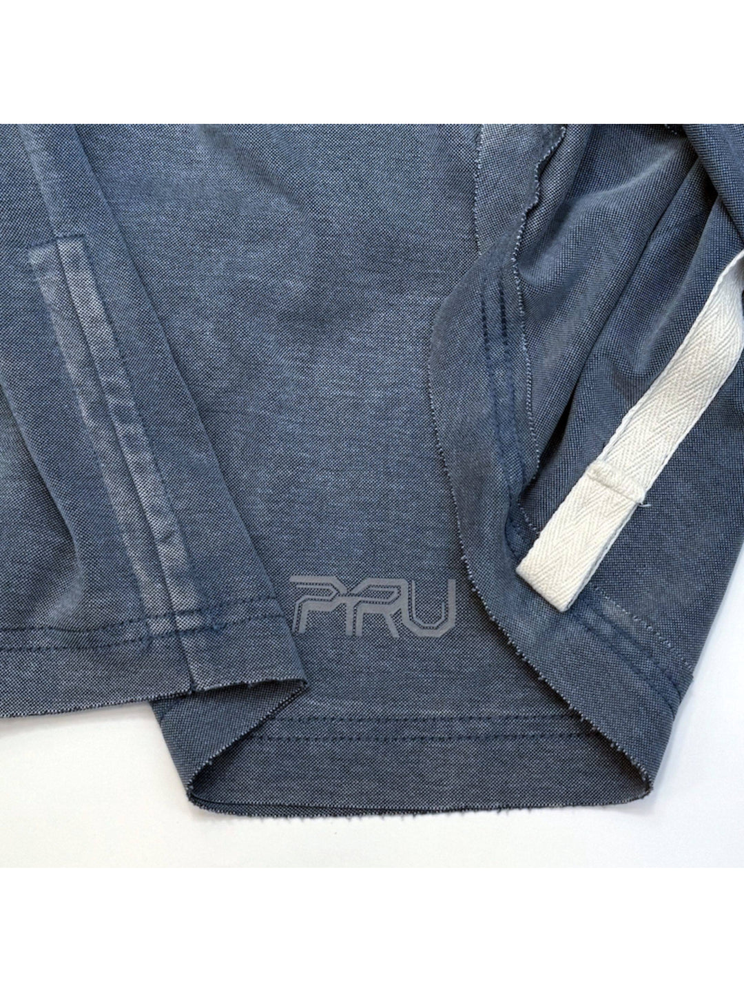 LIGHTSHADOW mycelium blue deconstructed technical tee — blue hem stitching, interior tape and PRU logo close-up