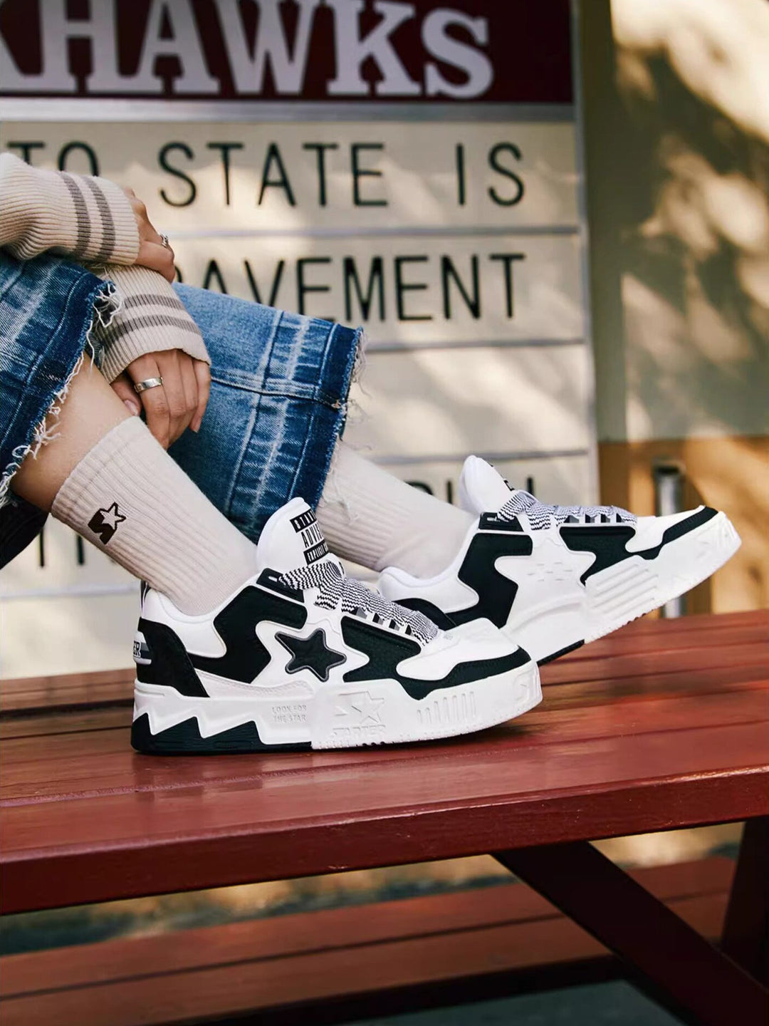 STARTER VOL 90S Panda Black sneakers worn with denim on a wooden bench, side view of both shoes