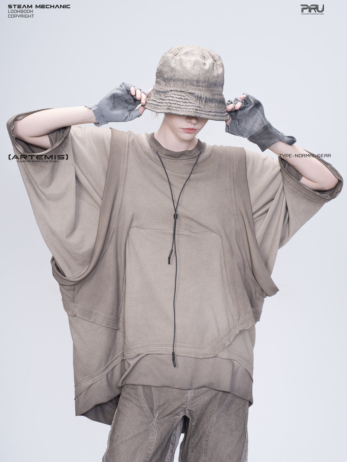 PIONEER mercury brown distressed nylon bucket hat — modeled view with both hands holding the brim