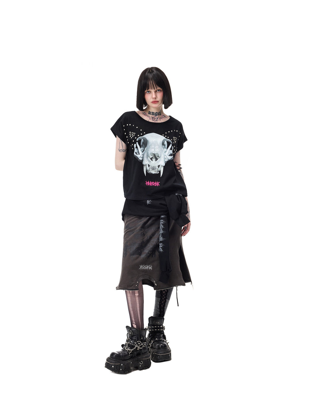 PINKSPINK CATACOMB reversible cat-skull tee in black — angled cat-skull-face view with hand behind, styled with a separate long skirt
