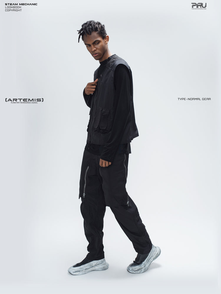 GAIA curved-blade technical pants in black — full-length side styling view showing the tapered leg