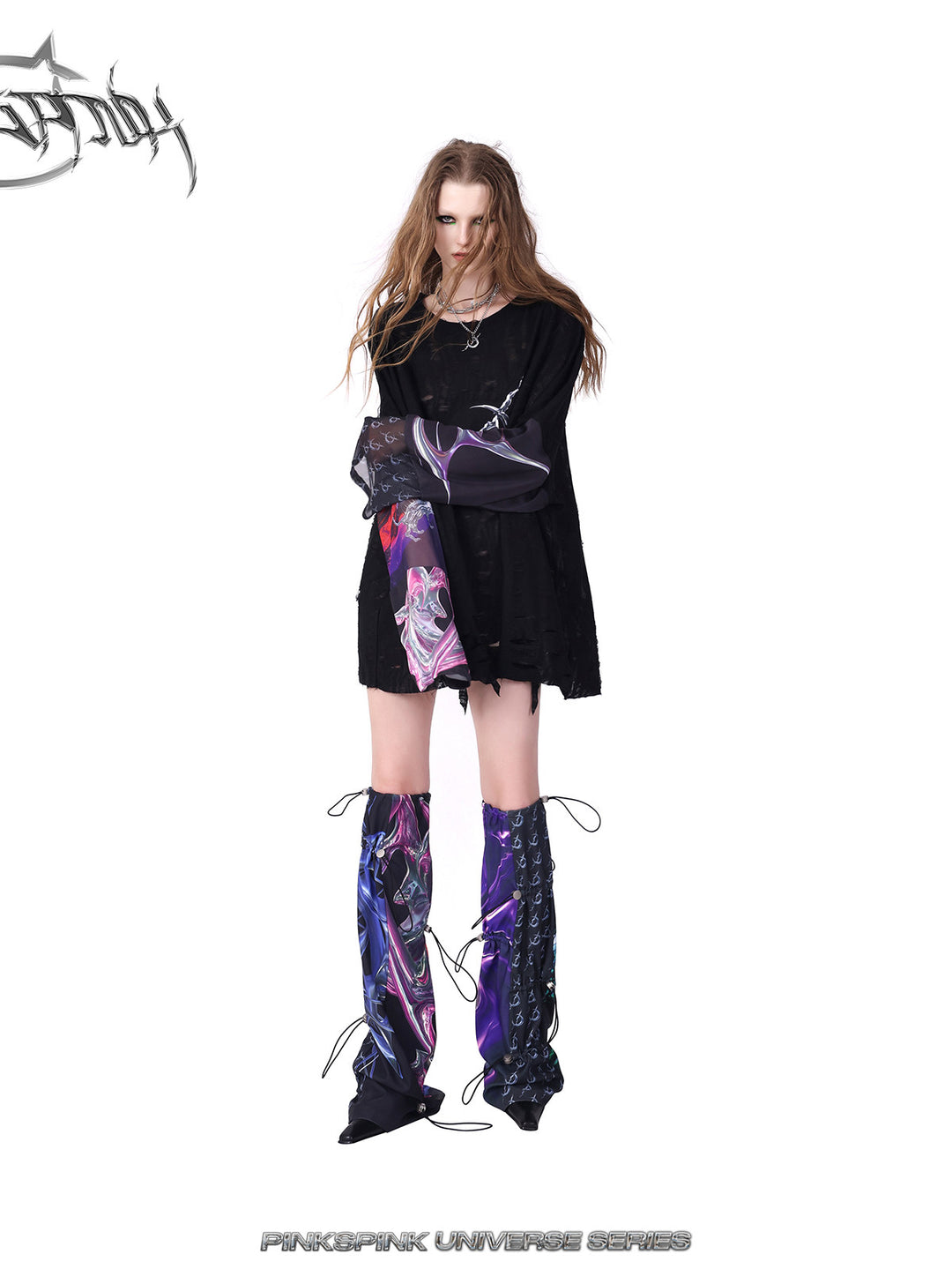 PINKSPINK COSMOS drawcord patchwork leg warmers in black purple multicolor — angled front modeled view with folded arms
