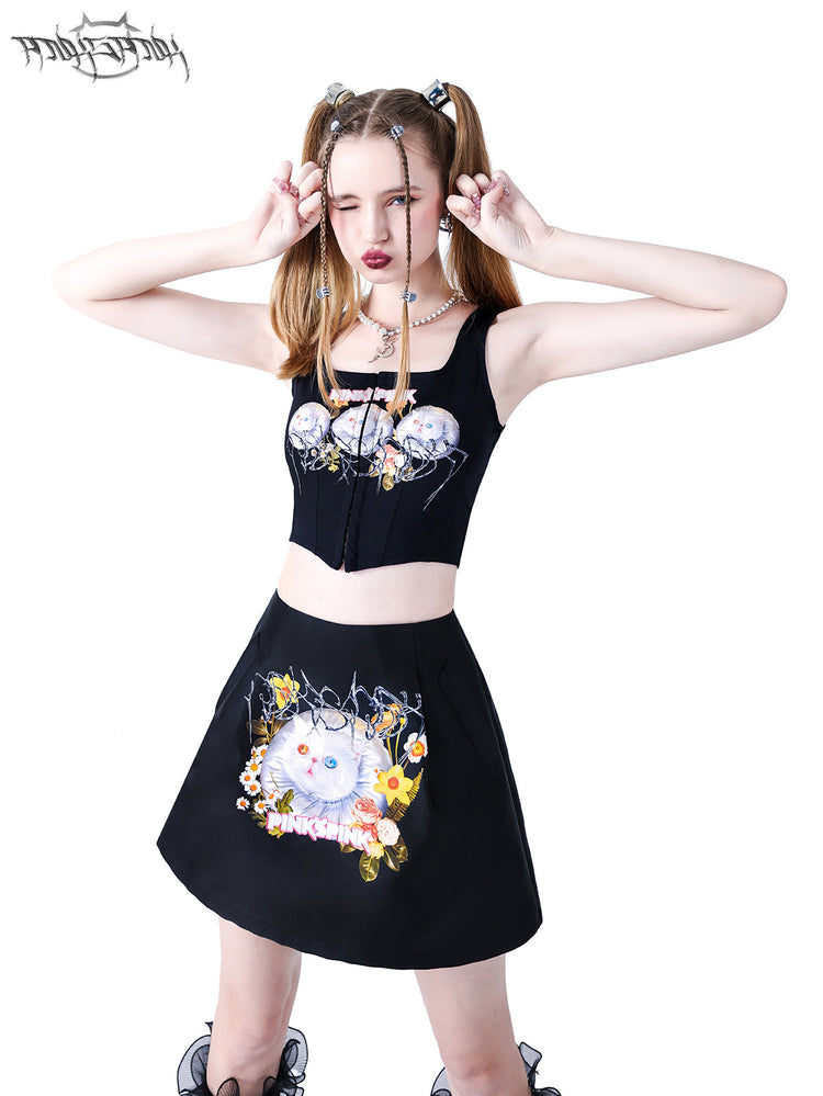 PINKSPINK GARFIELD graphic mini skirt — black close-up front modeled view with hands beside the face
