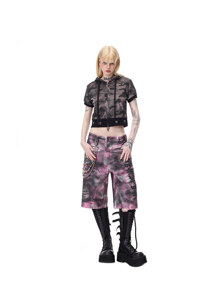 PINKSPINK ELECTRIC MOON coated camouflage denim shorts in pink-gray camouflage — front modeled view with hands resting at the pockets