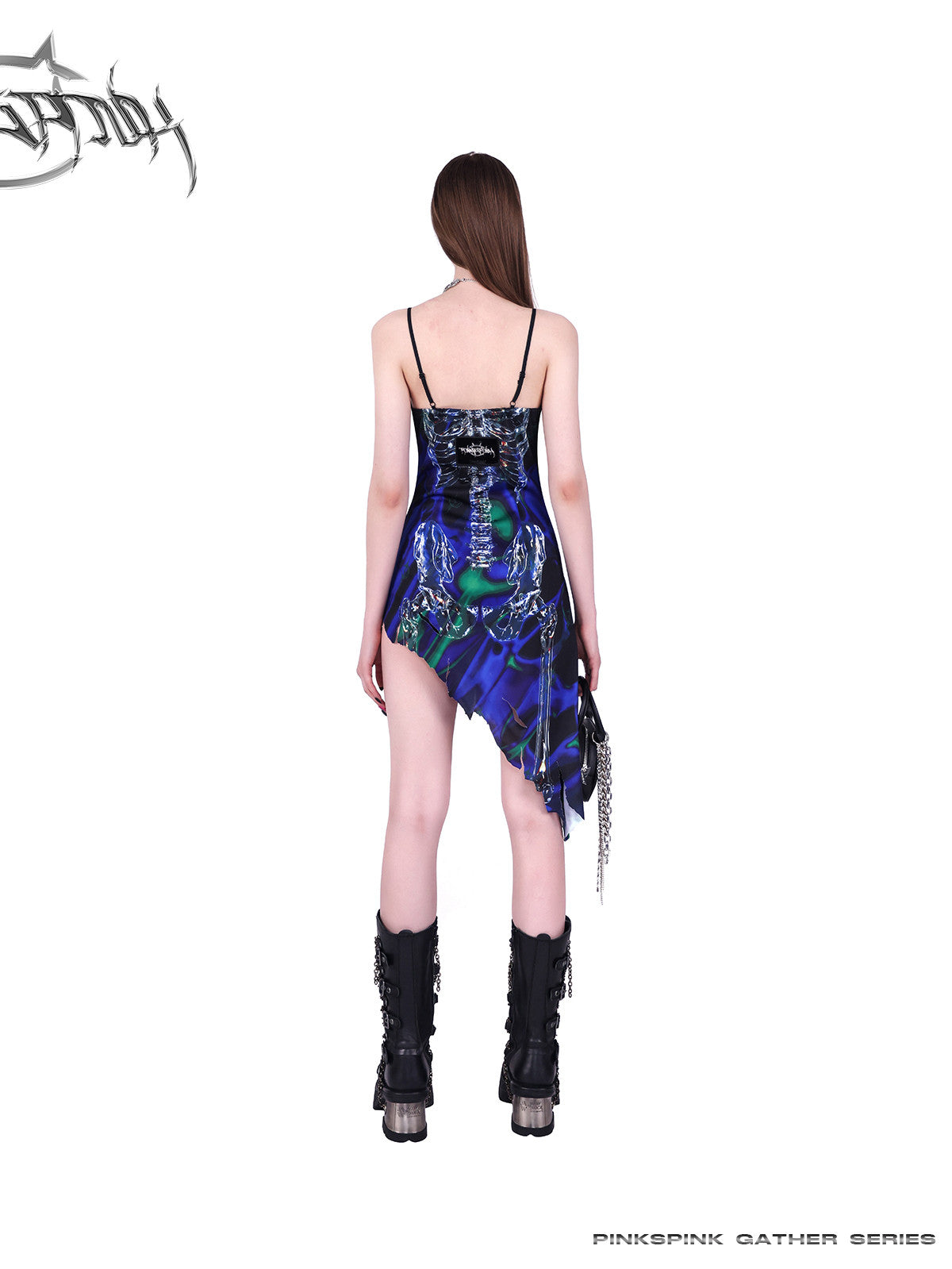 PINKSPINK COSMOS skeleton-print asymmetric slip dress in blue green multicolor — rear full-length modeled view showing the asymmetric hem
