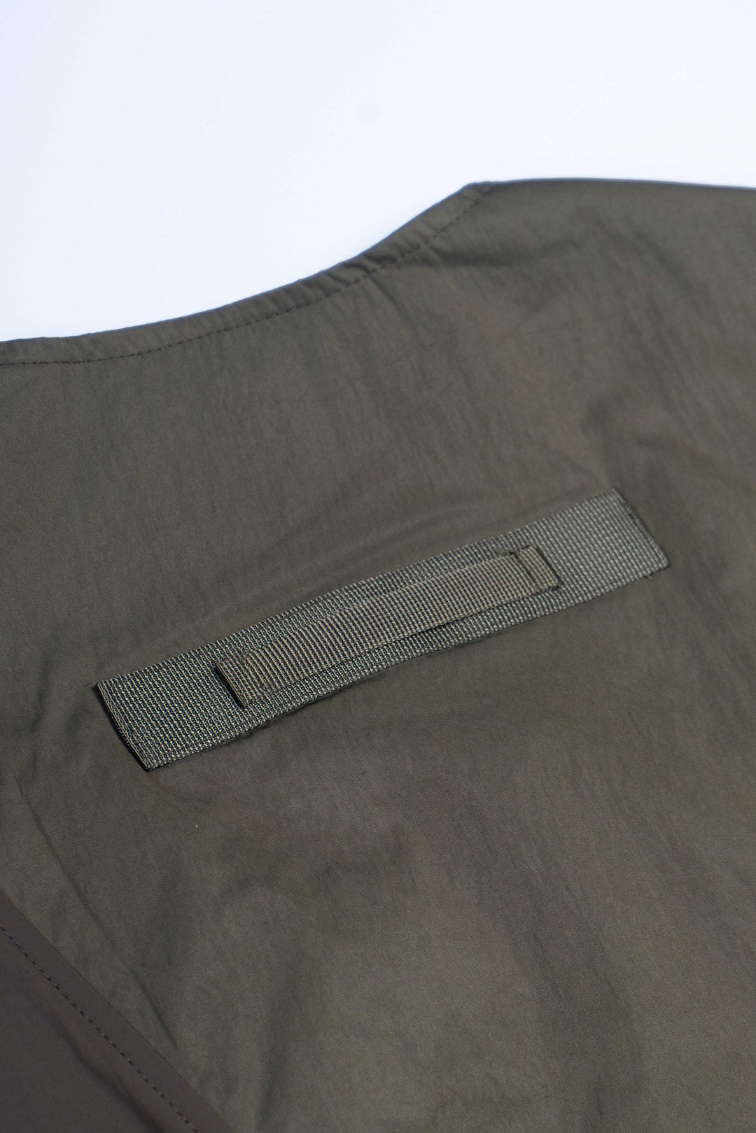 CLERIC utility nylon vest in vine gray green — close-up of the rear webbing loop and stitching