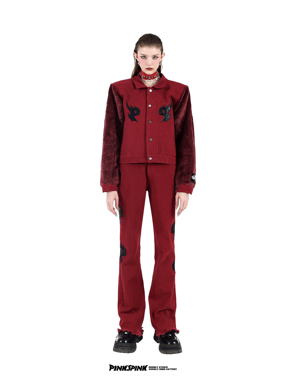 PINKSPINK SPIKE RING studded chain choker in red — full-length front modeled view with a red fleece-sleeve jacket and matching trousers