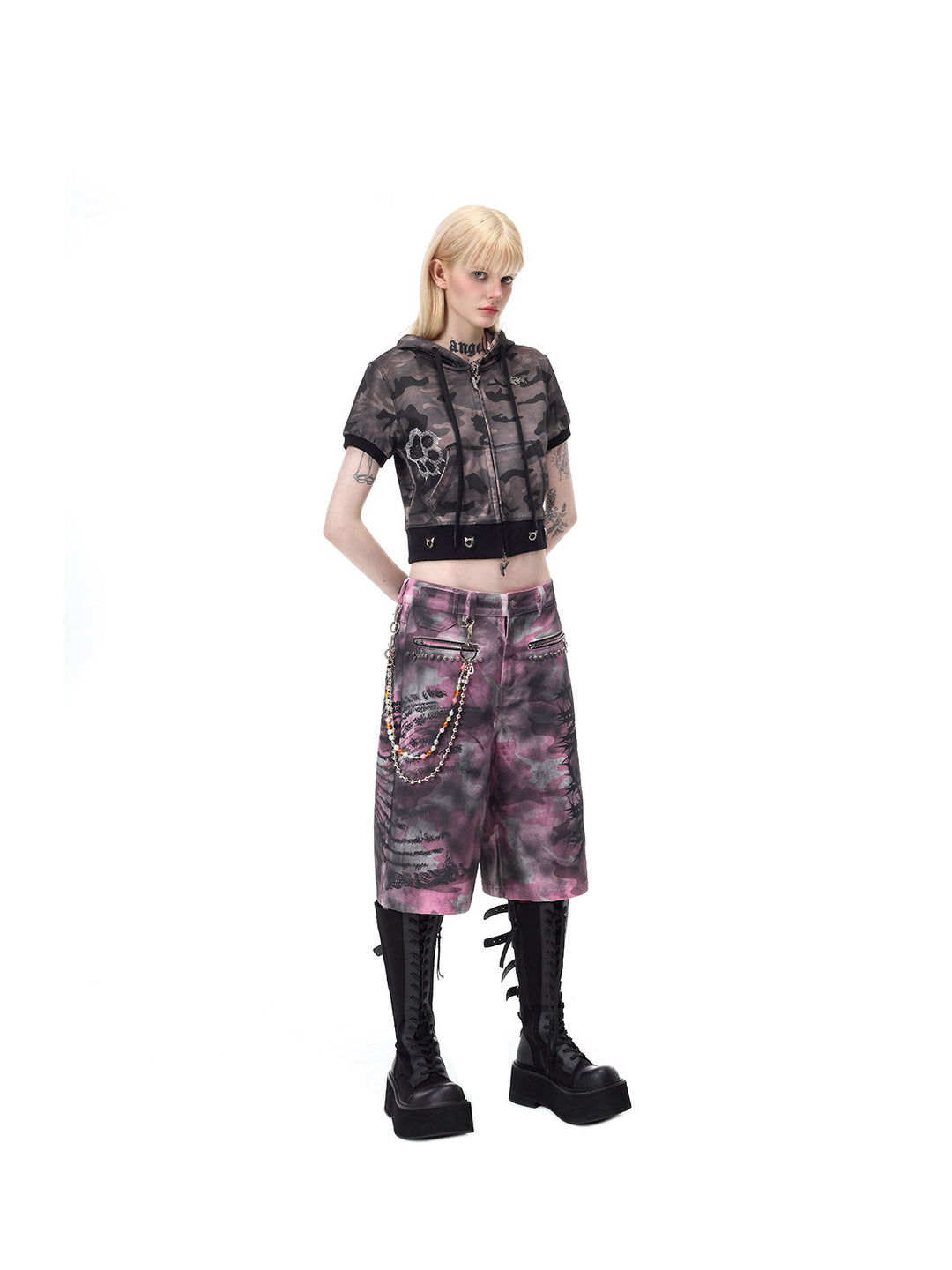 PINKSPINK ELECTRIC MOON coated camouflage denim shorts in pink-gray camouflage — full angled front view with hands behind the back