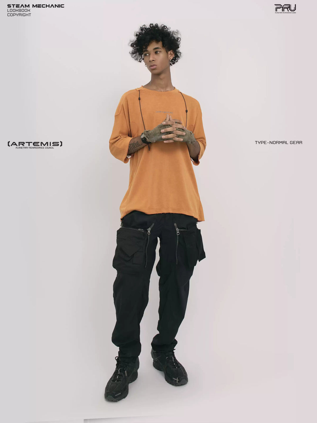 LIGHTSHADOW eclipse orange deconstructed technical tee — full-length front view with clasped hands, looking to the side