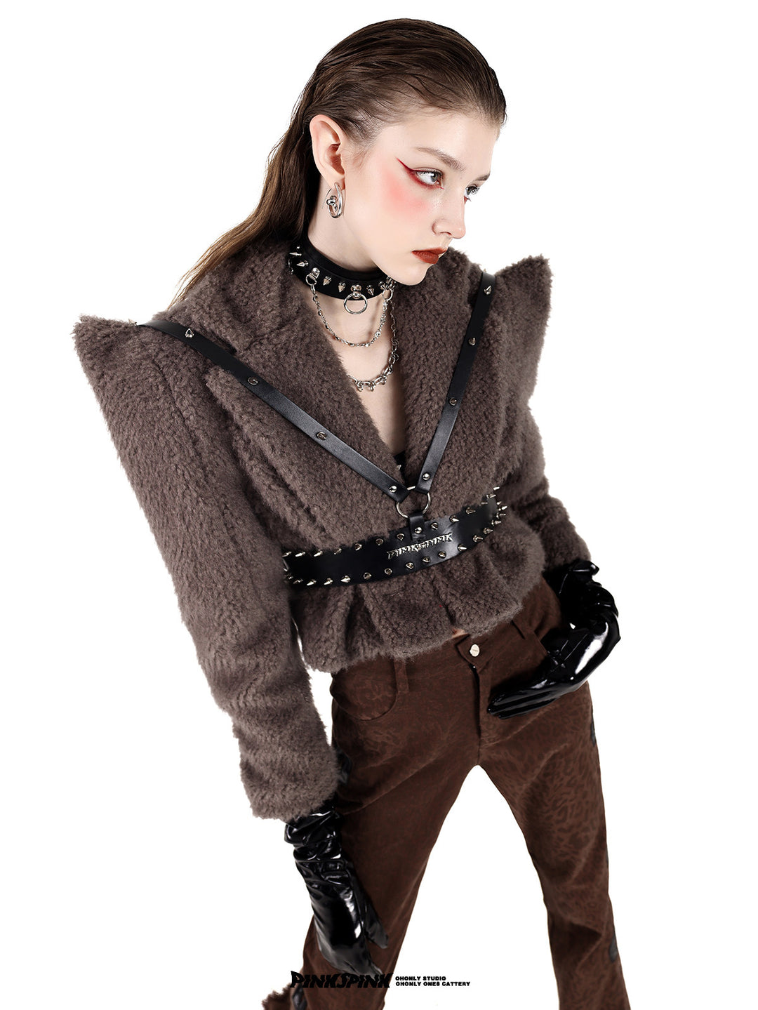 PINKSPINK SPIKE RING studded chain choker in black — angled modeled close-up with a brown pointed-shoulder jacket and harness