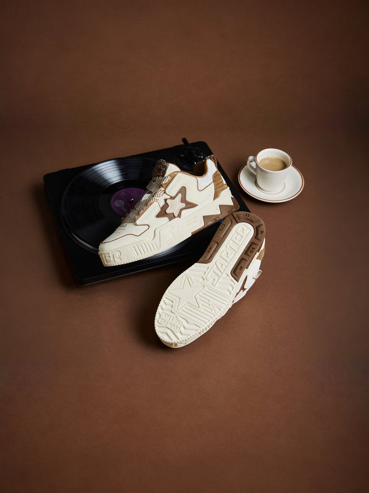 STARTER VOL 90S LATTE pair arranged on a record player beside coffee, showing the outer upper and patterned outsole