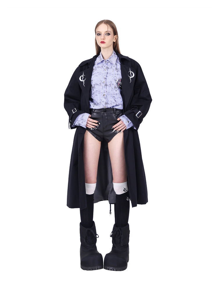 PINKSPINK ELECTRIC MOON reversible patchwork trench coat in black — open-front modeled view with hands on hips