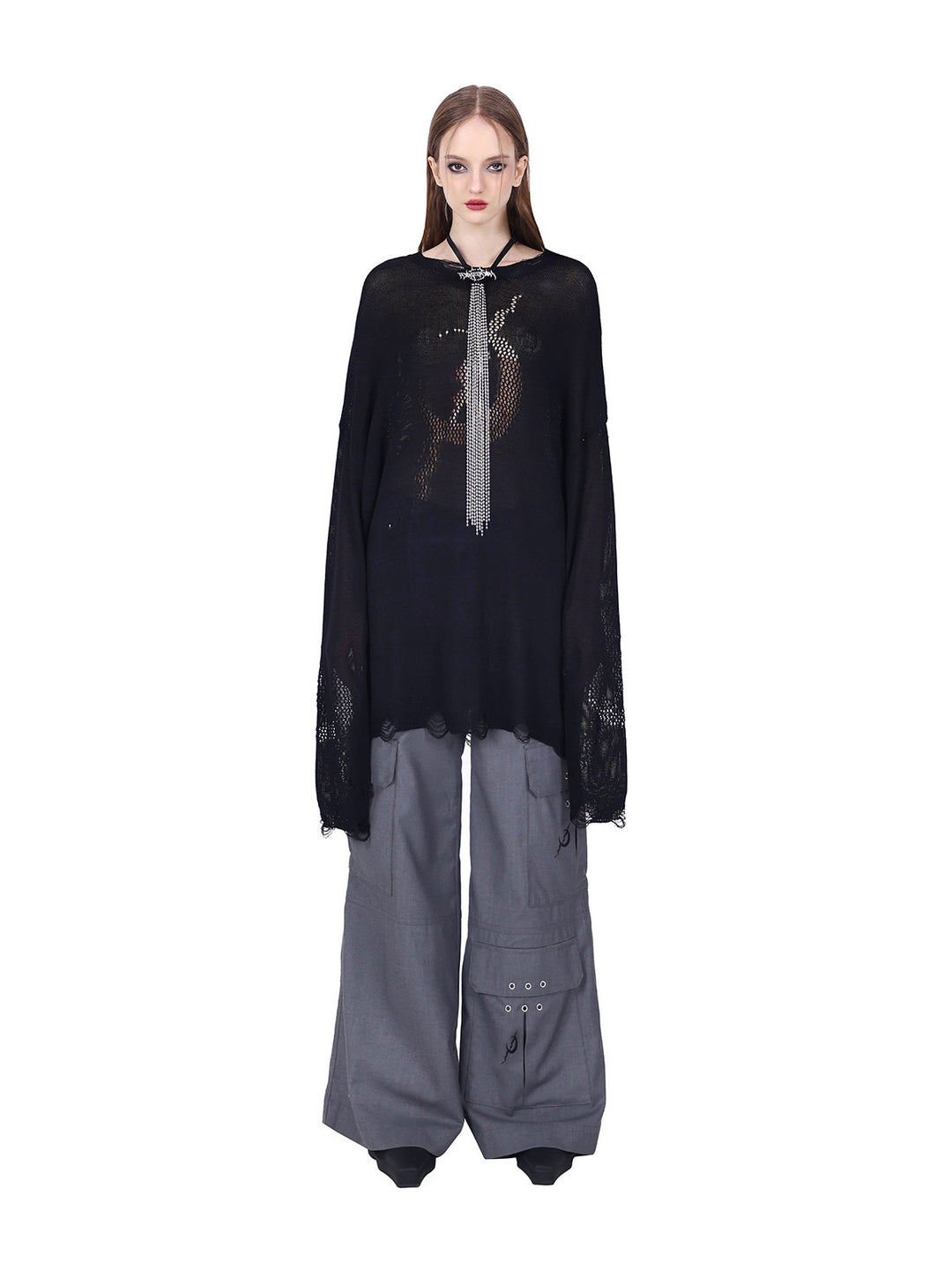 PINKSPINK ELECTRIC MOON distressed open-knit sweater in black — loose front view with extended sleeves over gray trousers