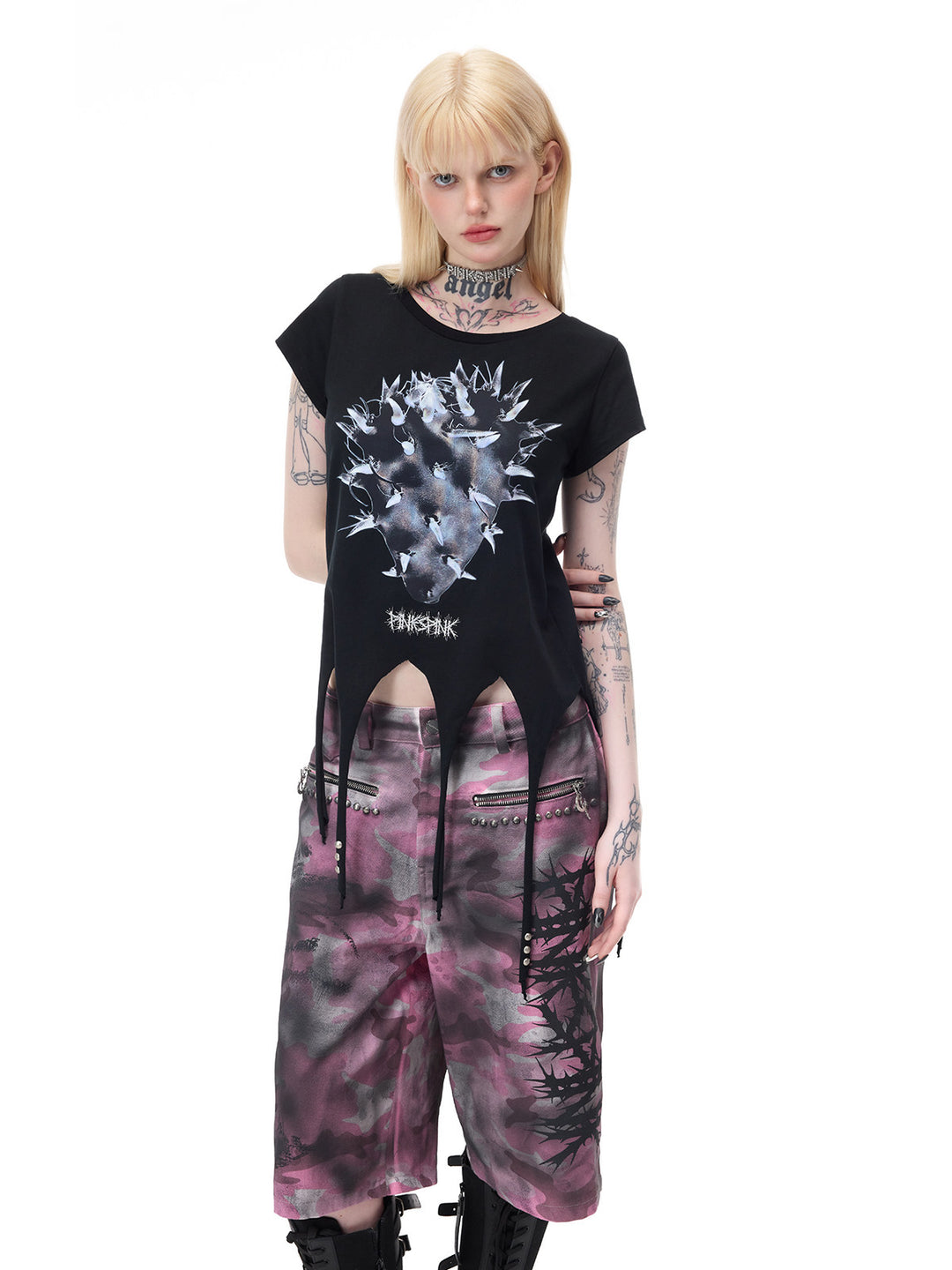 PINKSPINK PUNK CACTUS studded pointed-hem tee in black — three-quarter front modeled view with arms behind the back, also shown in the hero collage