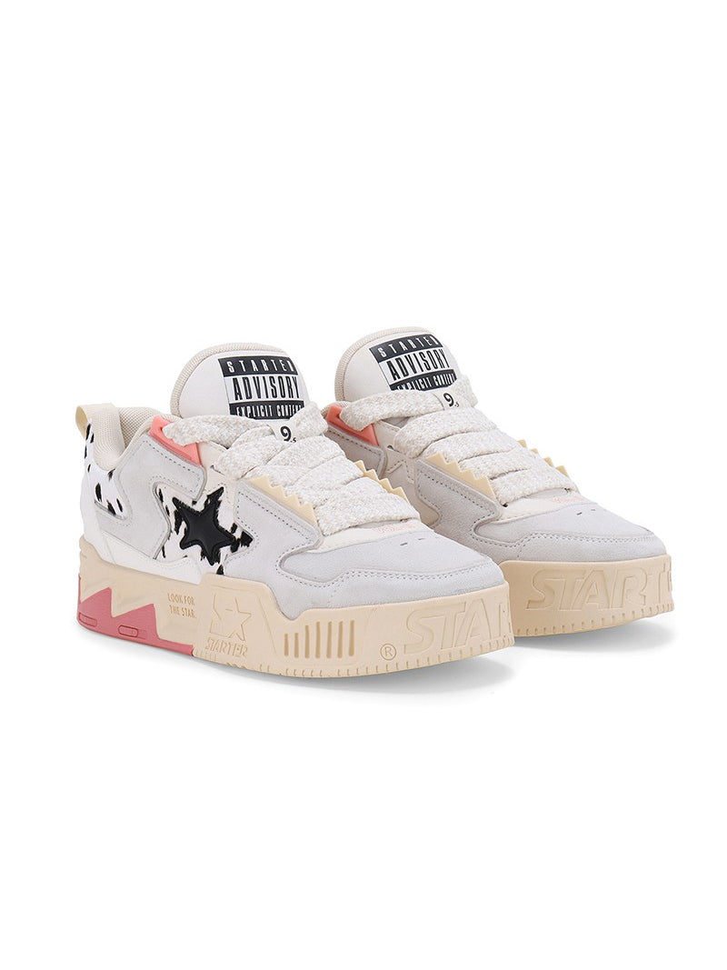 STARTER ZOO Cow Pink sneakers in a clean three-quarter studio pair view, showing cow-print star panels, broad white laces and pink heel accents