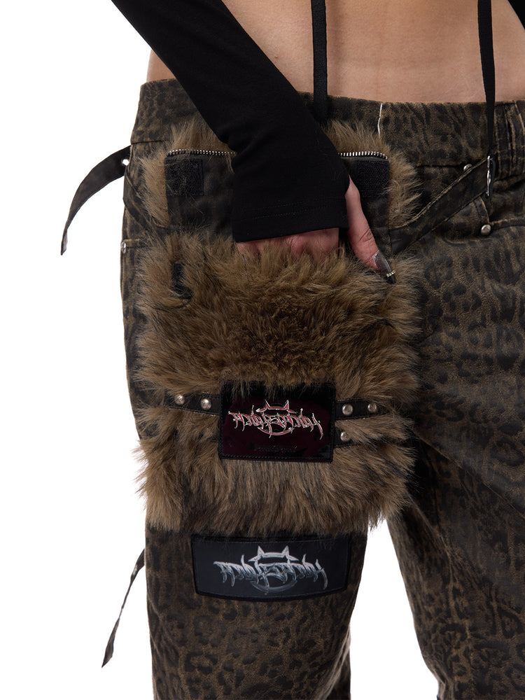 PINKSPINK LEOPARD RIOT detachable-pouch wide-leg pants — close-up of hand inside faux-fur pouch