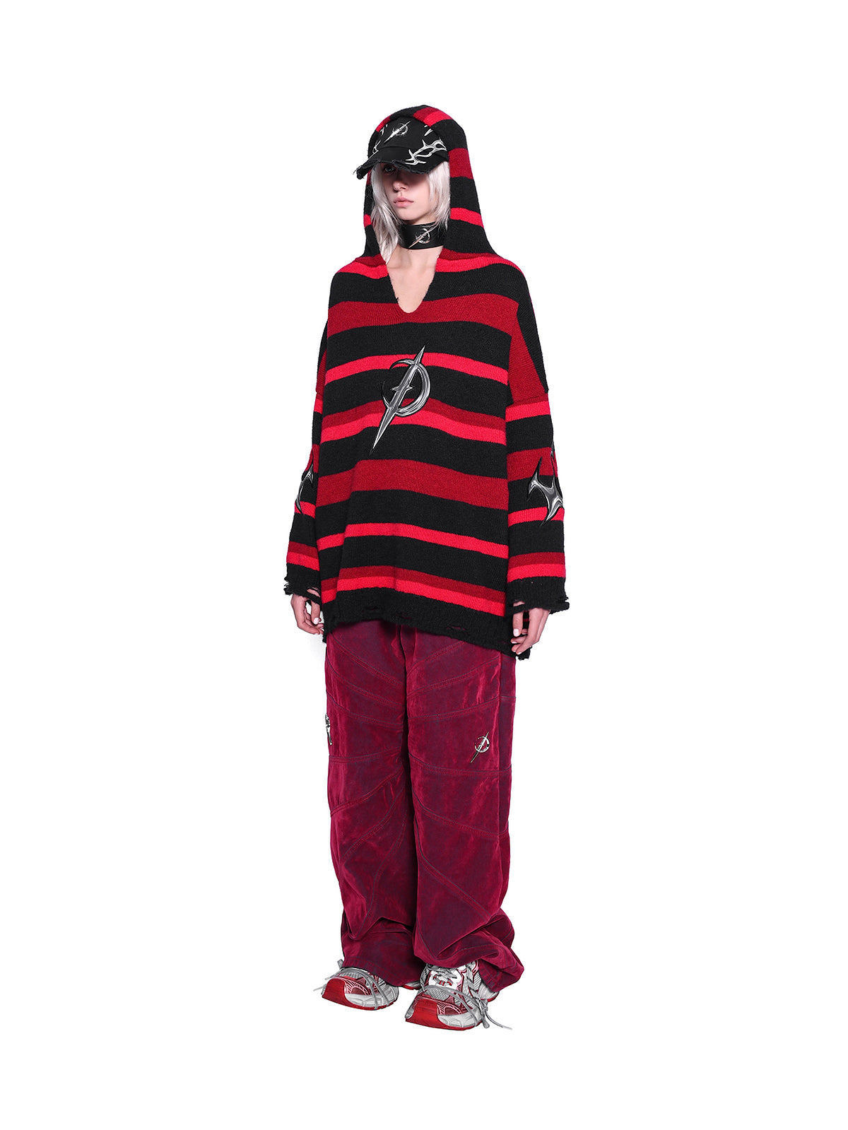PINKSPINK ELECTRIC MOON striped hooded sweater in BLACK AND RED — full-body angled front view styled with red trousers.