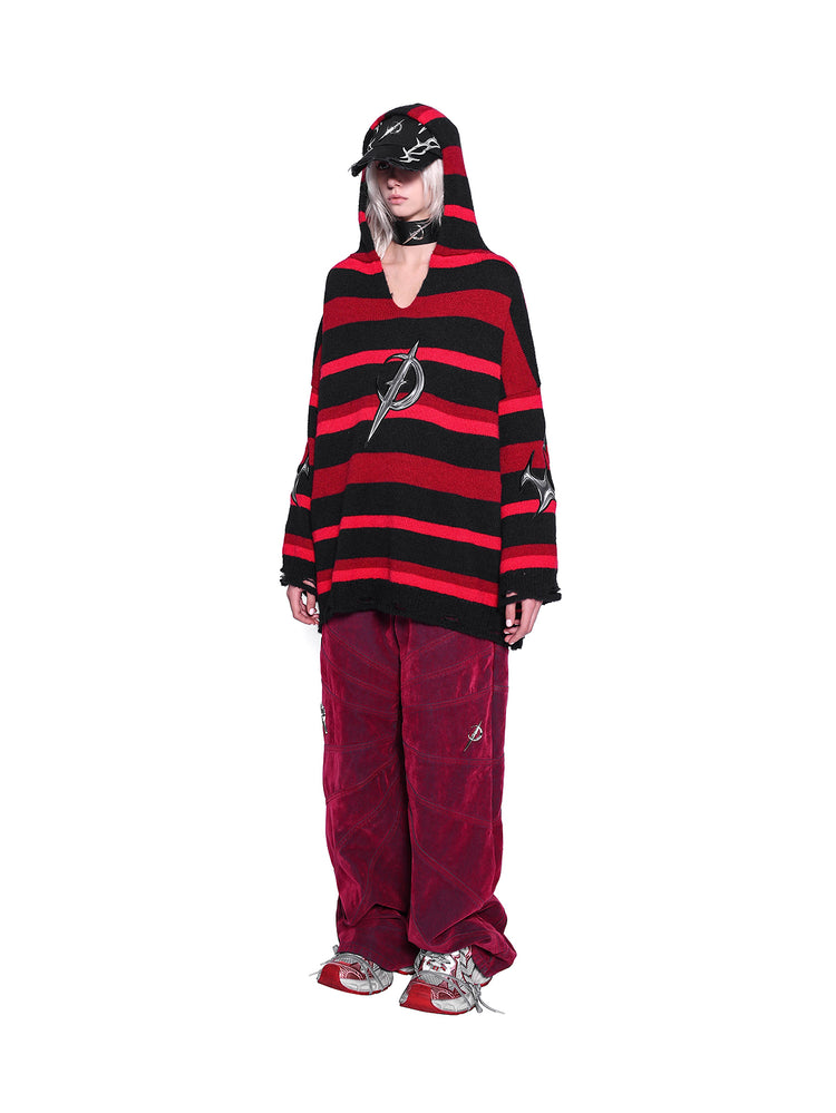 PINKSPINK ELECTRIC MOON striped hooded sweater in BLACK AND RED — full-body angled front view styled with red trousers.
