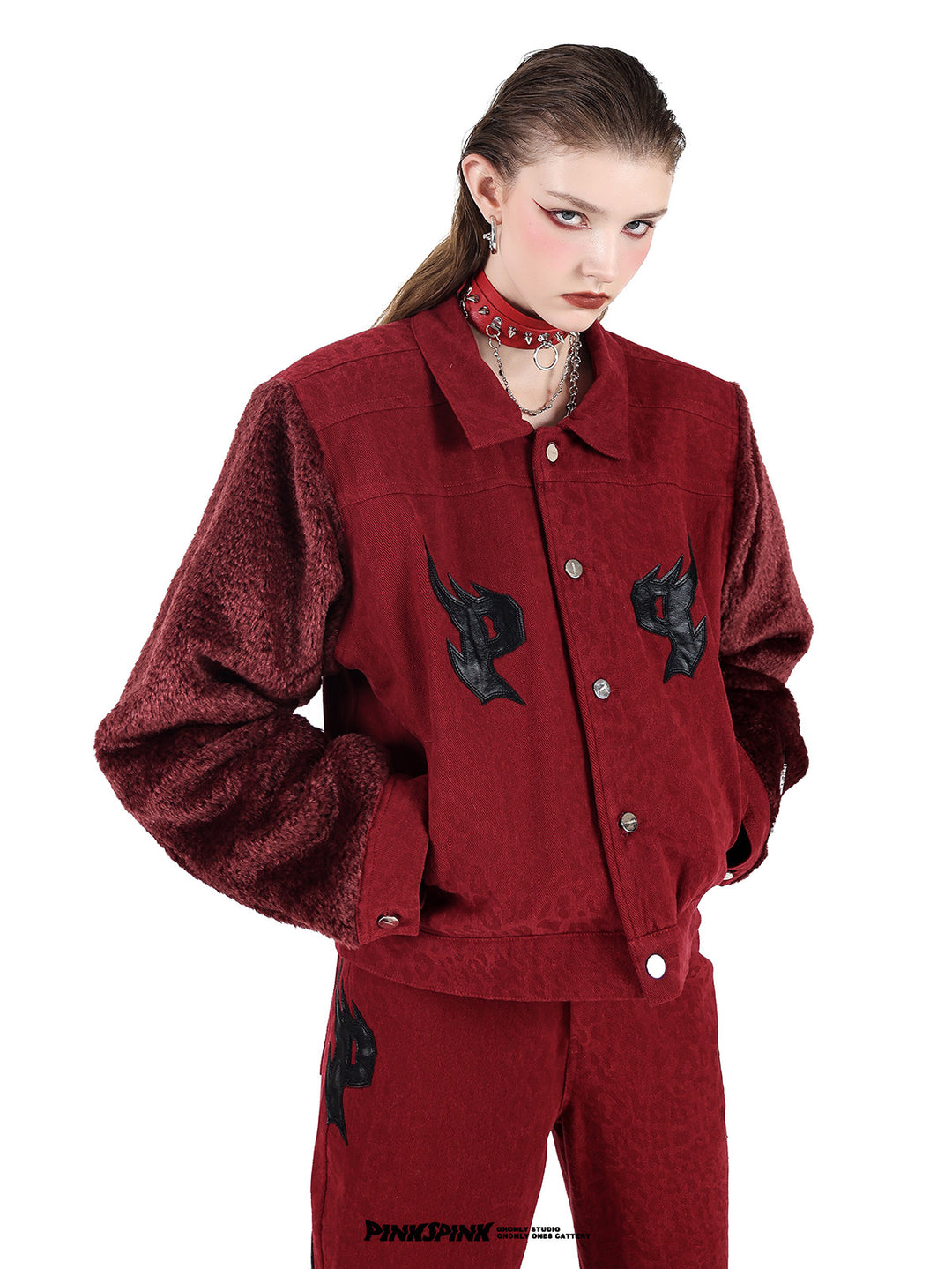 PINKSPINK SPIKE RING studded chain choker in red — angled modeled close-up with a red fleece-sleeve jacket
